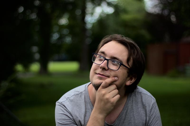 Man posing in front of some trees